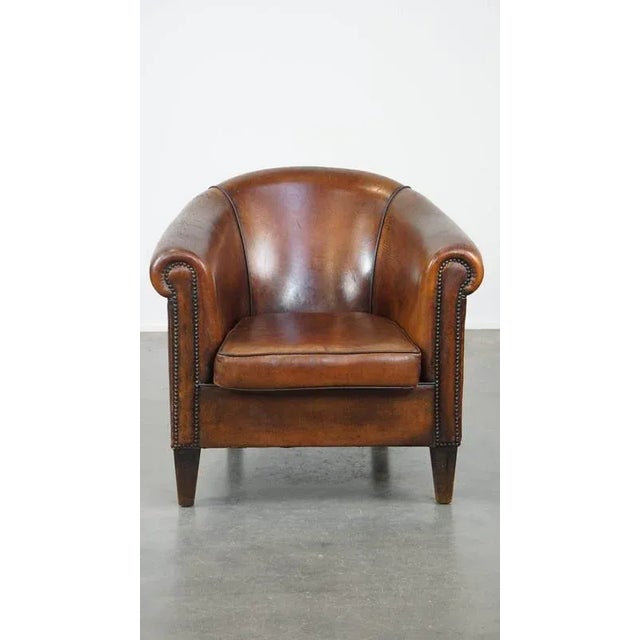 We are offering this cognac-colored, comfortable vintage sheepskin club chair with a generous seat. This stunning...
