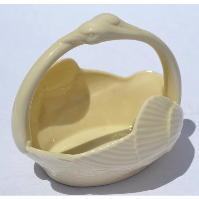 The Vintage Lenox Swan Basket in a tan creamy off-white finish, featuring a sculpted swan design with a gracefully curved...