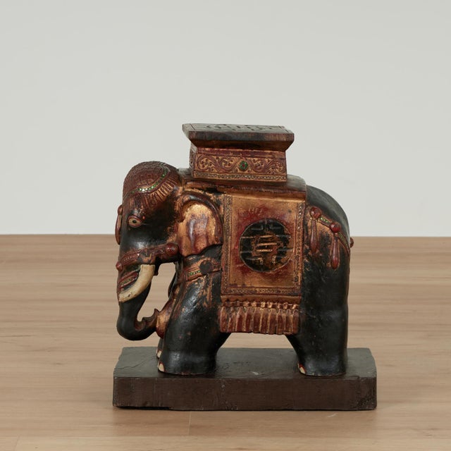Impressive antique Indian elephant stand carved from a hardwood featuring a carved character on the top over a fancy...