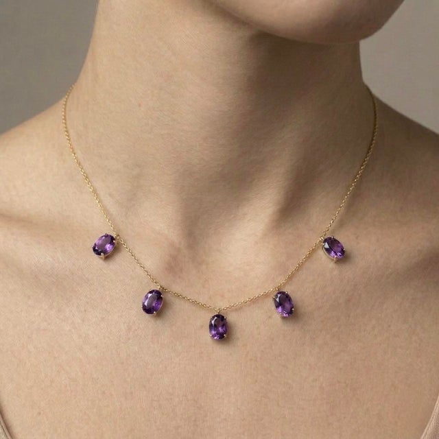 Elegant and timeless, this Amethyst Dangle Station Necklace showcases five beautifully faceted oval-cut amethyst gemstones...
