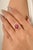 This exquisite 14K yellow gold ring showcases a vivid oval-cut ruby embraced by a clover-shaped halo of sparkling round...
