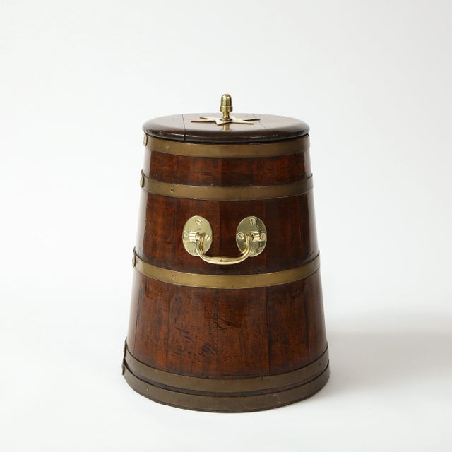 Of rounded flaring form with five concentric brass bands; with removable lid with molded edge surmounted by a centered...