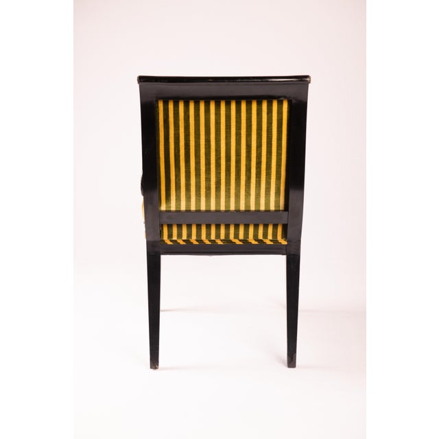 Beautiful ebonized and parcel gilt vintage Regency-style armchair. The stripe velvet upholstery is newer. This chair...