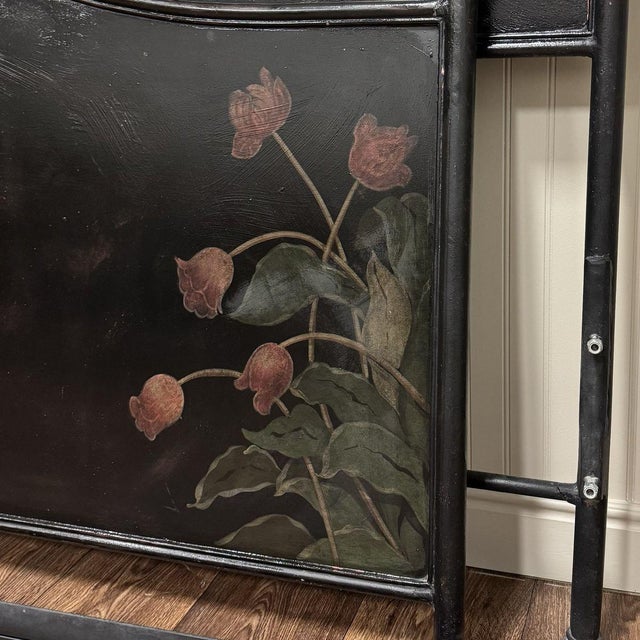 Vintage king-size metal bed frame with hand-painted floral details in an ebonized black finish. The headboard and...
