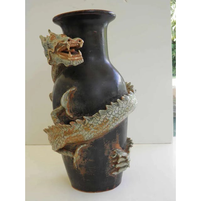 A large dynamic gorgeous ceramic Thai dragon vase. A black ground patina with a figurative dragon-detailed with scales,...