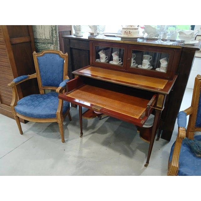 This elegant Louis XVI style French writing desk features a top enclosed bookcase for books or collectibles. A pull-out...