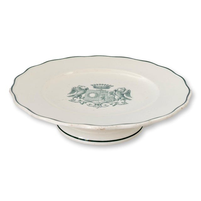 A stunning late 19th-century transferware cake plate featuring an intricate green crest with a regal crown, twin eagles,...