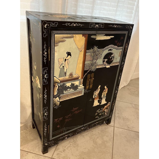 This is a beautiful Mid-Century (1950s) Chinese Black Lacquer Cabinet With Mother of Pearl Inlays. The beautiful inlays...