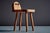 This stool features a solid pine construction with a broad, gently rounded seat and a sculptural backrest with three...