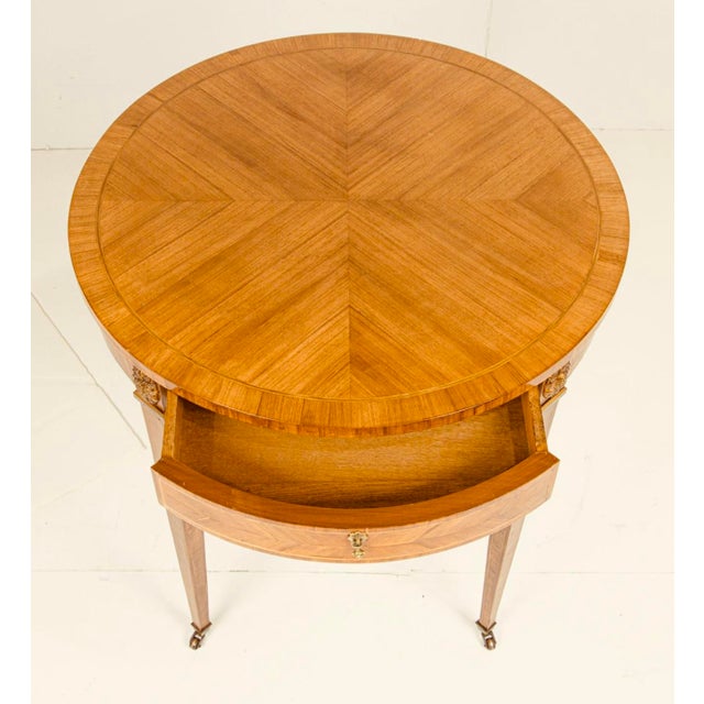 An elegant Neoclassical-style side table, attributed to Baker Furniture, distinguished by refined proportions, beautifully...