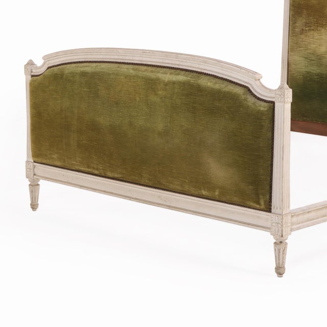 A refined French Louis XVI style bed in painted wood. The simple arched headboard and footboard feature wonderful...