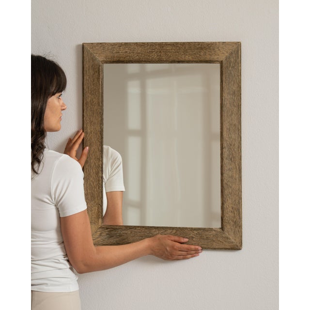 This 19th century oak mirror from France is framed in pale, textured oak, a mirror with a broad, softly worn border. The...