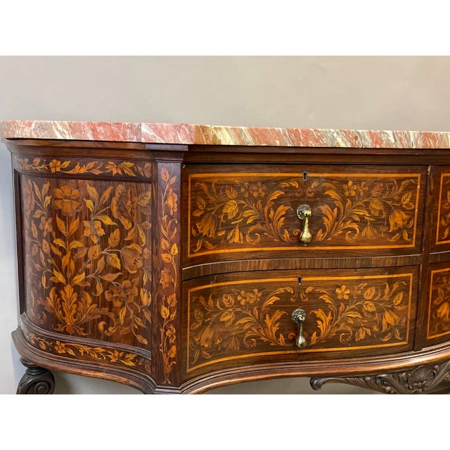 19th Century Dutch Style Marble Top Marquetry inlaid server of serpentine form with a shaped marble top over a conforming...