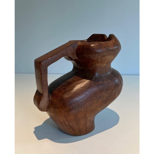 This lovely and unusual Brutalist pitcher is made from carved wood. It is a French work in the style of Alexandre Noll....