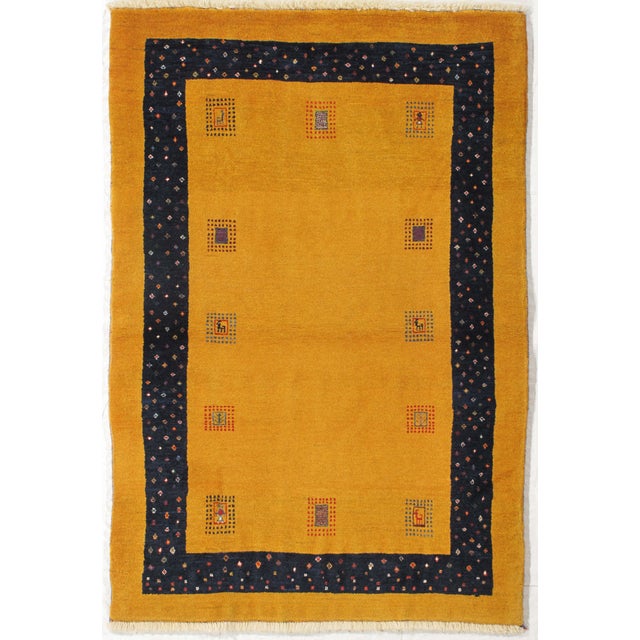 Vintage hand-knotted Persian Lori Gabbeh wool rug with a golden yellow field featuring small geometric panels with...