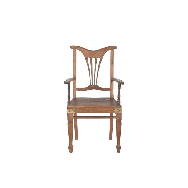 This Vintage Anglo-Indian Teakwood Armchair is handcrafted from solid teakwood, featuring a graceful shield-style back...