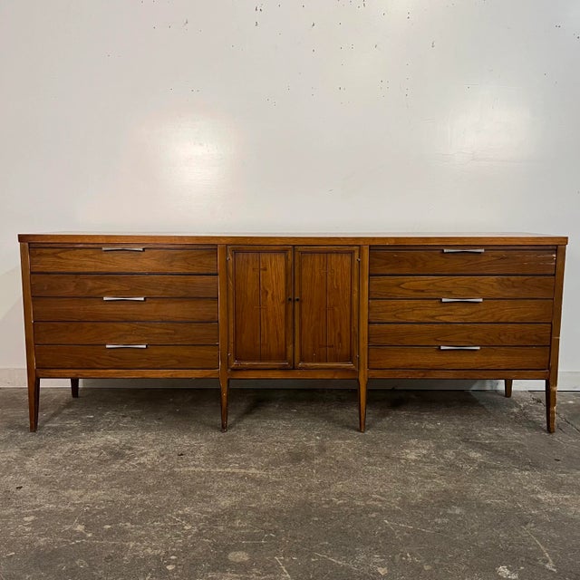 Lane Tuxedo walnut lowboy dresser. This pieces features 3 drawers on either side of doors in the middle of piece that open...