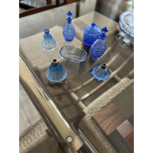 Stunning art deco vanity set made of pressed blue glass, dating from the 1930s–1940s. The set includes multiple perfume...