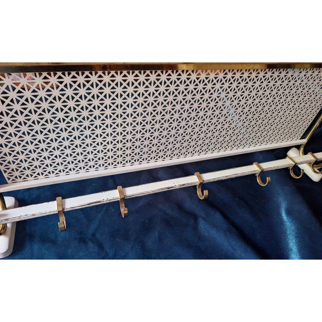 Brass and perforated metal wall mounted coat and hat rack dating from the 1960s, with 6 adjustable sliding brass hooks.