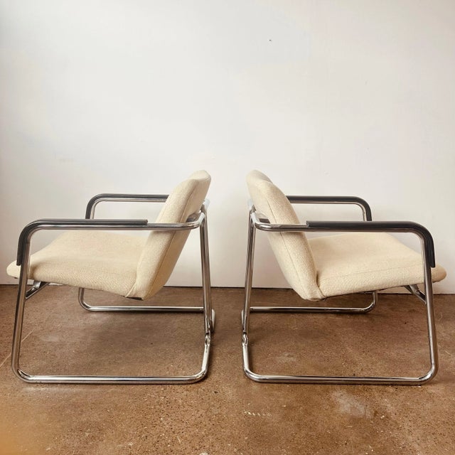 Mid-century modernist accent or client arm chairs with tubular chrome frames and black molded plastic arms. Dated 1977,...