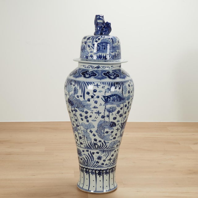 Impressive pair of palace size Chinese porcelain lidded urns with foo dog handles and hand decorated with aquatic scenes...