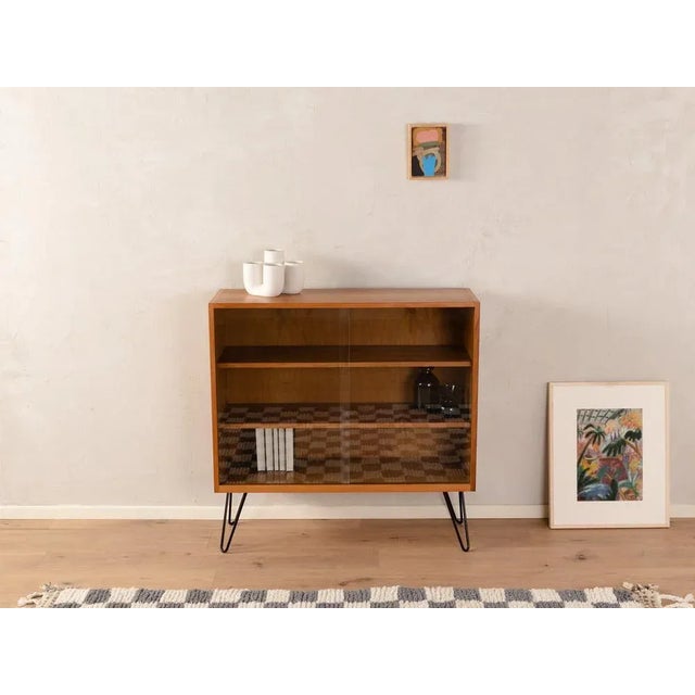 Semi solid showcase in Scandinavian style from the 1950s. Corpus in walnut veneer with two sliding glass doors, two...