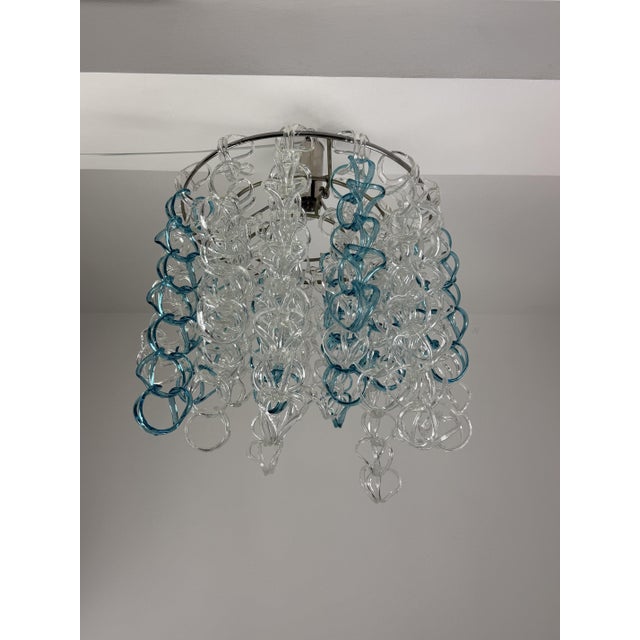 Murano glass chandelier in the style of Angelo Mangiarotti for Vistosi, 1960 Circular metal frame with cascading glass....