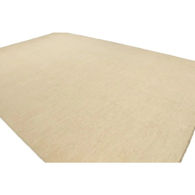 Hand-knotted in wool, this 12'11''x12'11'' contemporary rug in beige as an addition to the Rug & Kilim Textural...