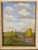 Mid century framed painting of farm landscape with farmhouse, field, and windmill and rolling clouded sky. Painting is...