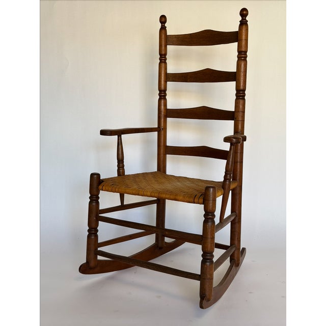 1900s Antique Ladder Back Rocking Chair with original woven reed seat. Great piece with a lot of patina