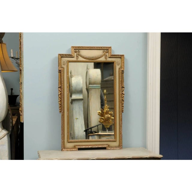 A pair of painted and gilded Swedish mirrors from the early 20th century. This pair of Swedish mirrors feature a rather...