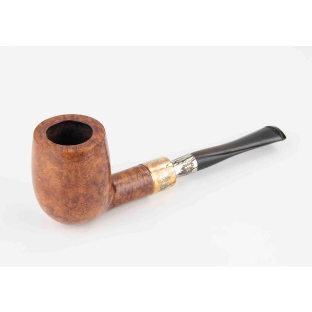 This pipe is an elegant example of traditional English craftsmanship, combining briarwood with silver details. The bowl is...