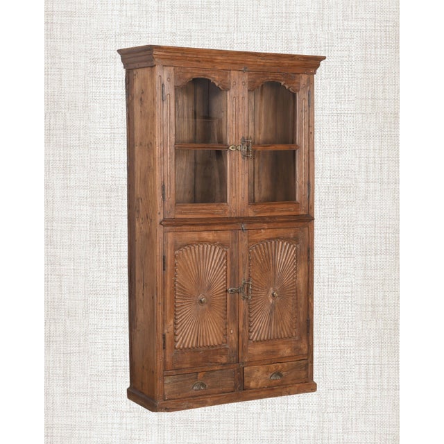 Four doors- two glass above, two solid below. A cabinet that knows exactly what it is. This antique Indian armoire in warm...