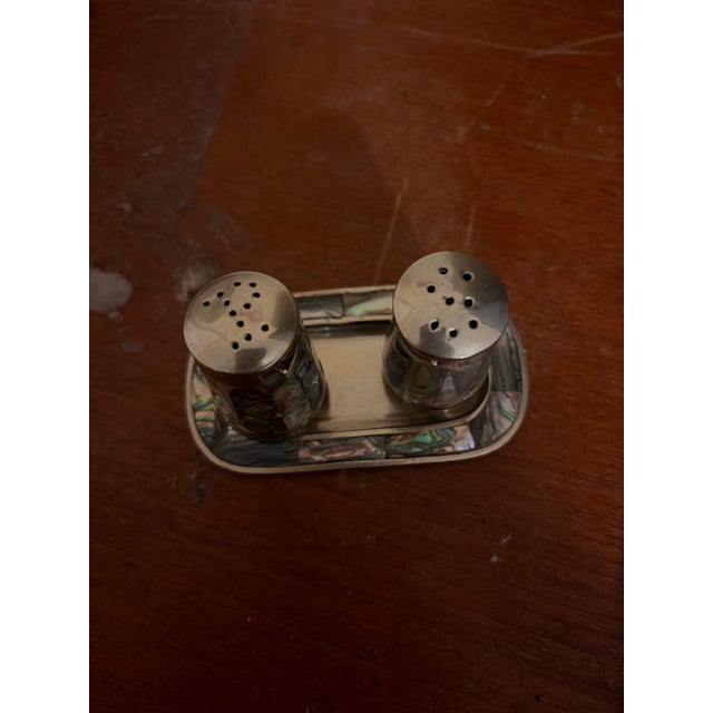 vintage Mexican Alpaca silver-tone salt and pepper shaker set featuring shimmering, iridescent abalone shell inlays on a...