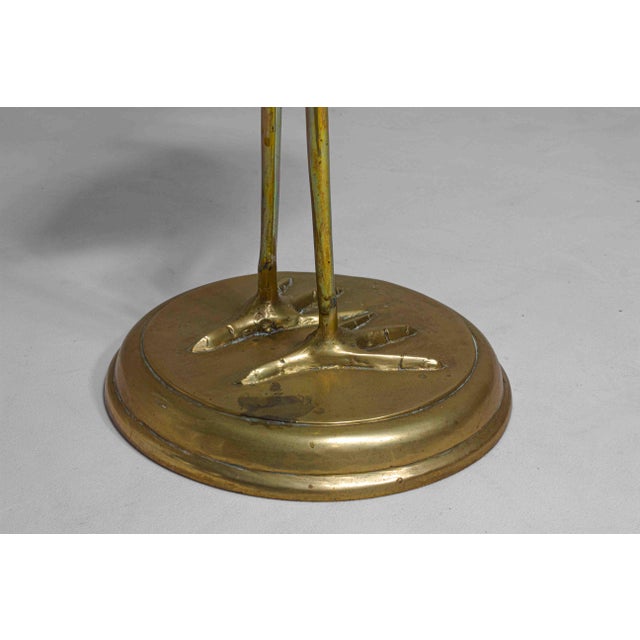 This is brass heron sculpture in the Hollywood Regency style, features a tall, slender heron with a curved neck, standing...