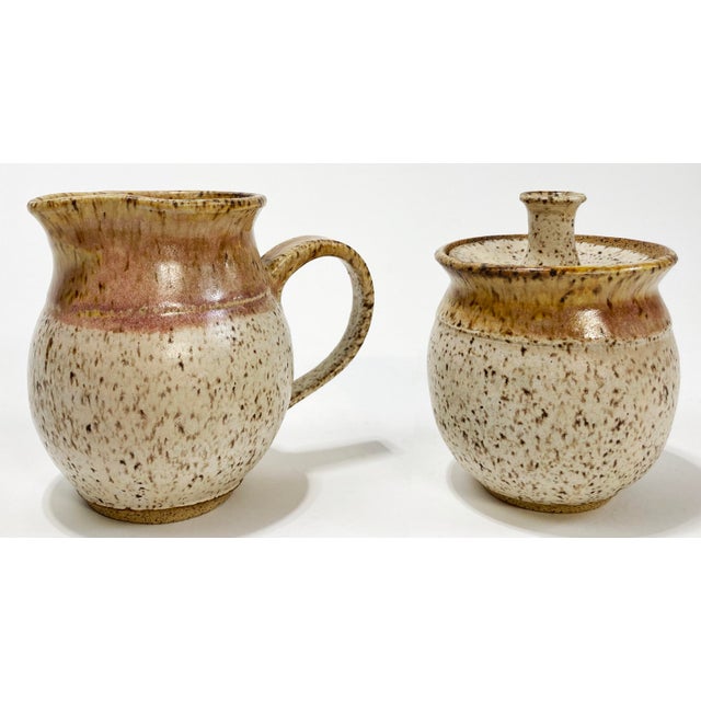 Unique vintage Studio Pottery ceramic creamer and sugar set. Feature gray speckled clay with warm brown and pink blend at...