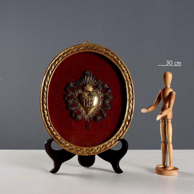 Ex-voto Sacred Heart in embossed and carved silver with a small amber cross. The Sacred Heart is presented in a gilded...