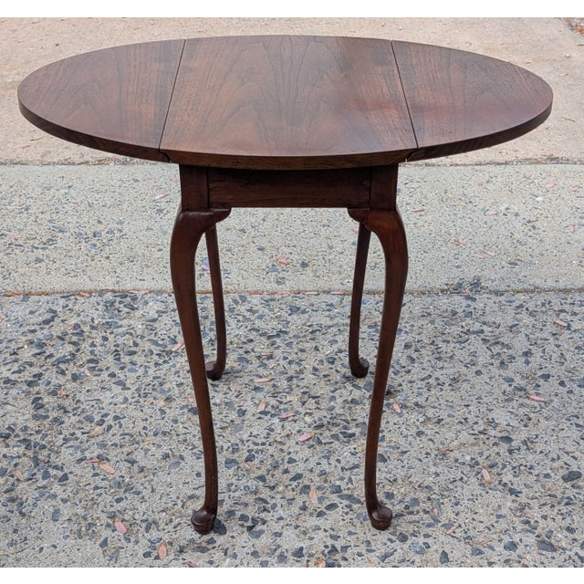 This Baker Furniture Solid Mahogany Pembroke Table is a masterclass in traditional American cabinetry, offering both...