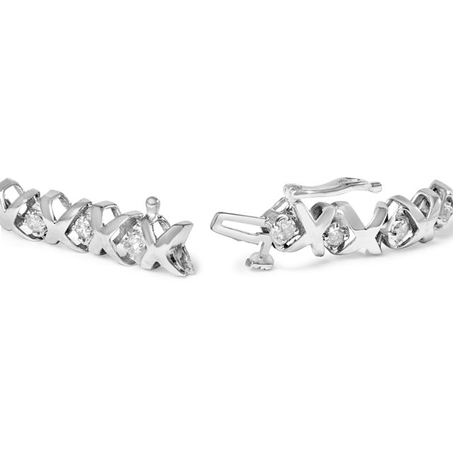 Indulge in the ultimate luxury with this stunning 10K White Gold Diamond X-Link Tennis Bracelet. With 56 natural round...