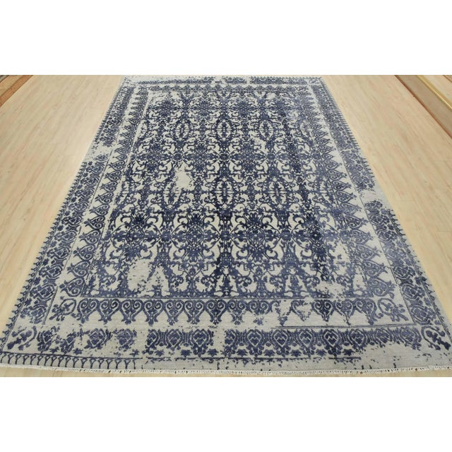 A modern traditional Oriental rug hand-knotted with a wool and viscose pile on a cotton foundation. This stunning area rug...