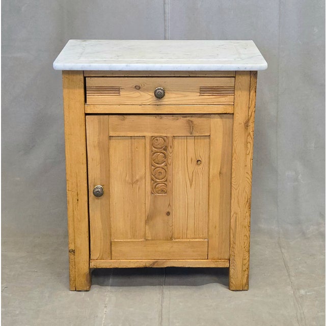 A charming antique European (German or Eastern European) rustic pine nightstand topped with a Carrara marble slab that is...