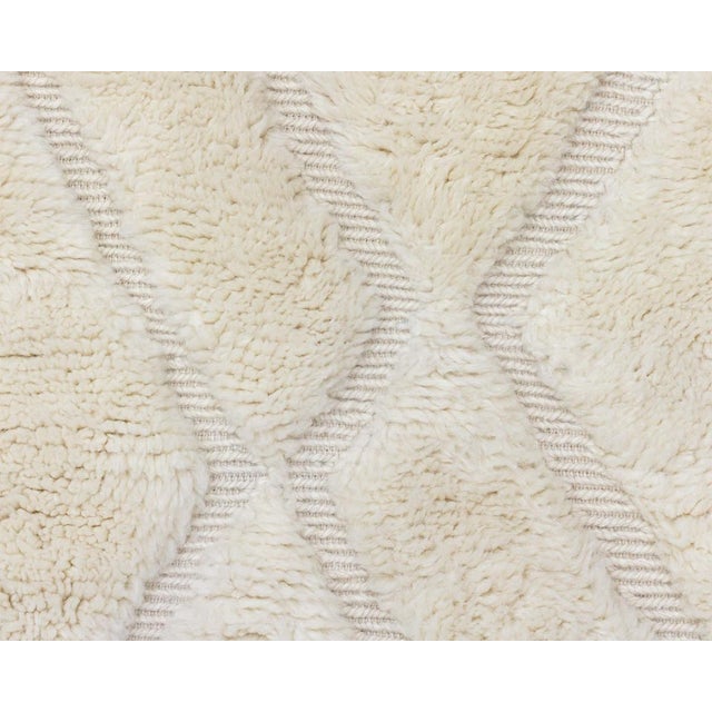 Elegant hand-knotted rug in a Natural Wool, textured with a subtle flat-woven geometric patterns. Ideal for a minimalist...