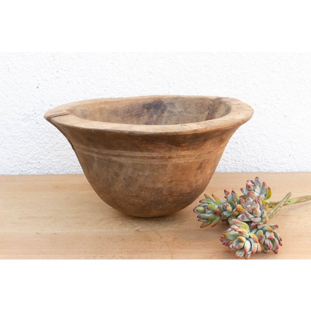 There is something deeply grounding about holding a vessel that was hewn by hand from a single block of wood. This antique...