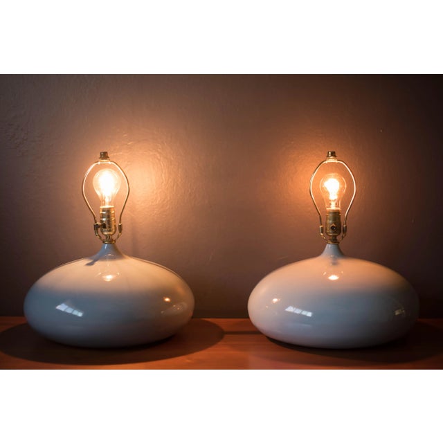 Vintage pair of sculptural ceramic table lamps, circa 1960s. Features a unique round base in a light gray glossy finish....
