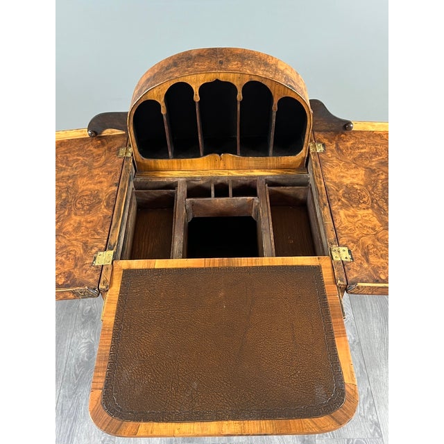 An elegant Queen Anne style Davenport desk in burr walnut veneer, made in the first half of the 20th century. This refined...