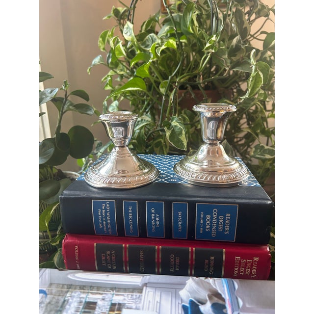 These sterling silver weighted candlestick holders are so similar that they fool the eye. They are an unmatched pair each...