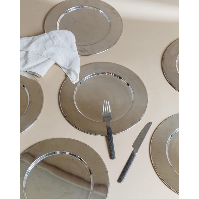 Set of six elegant vintage underplates from Italy, made of silver-plated metal and dating to the 1970s. with their clean,...