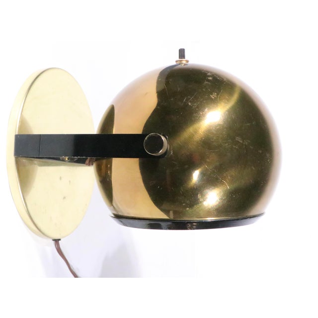 Pair of mid century ball form brass table lamp, wall light, pin up sconces. The lights feature brass shell ball form...