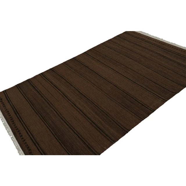 Handwoven in wool, circa 1950-1960, this 5x8 vintage Afghan tribal kilim rug with chocolate brown and black stripes, is an...
