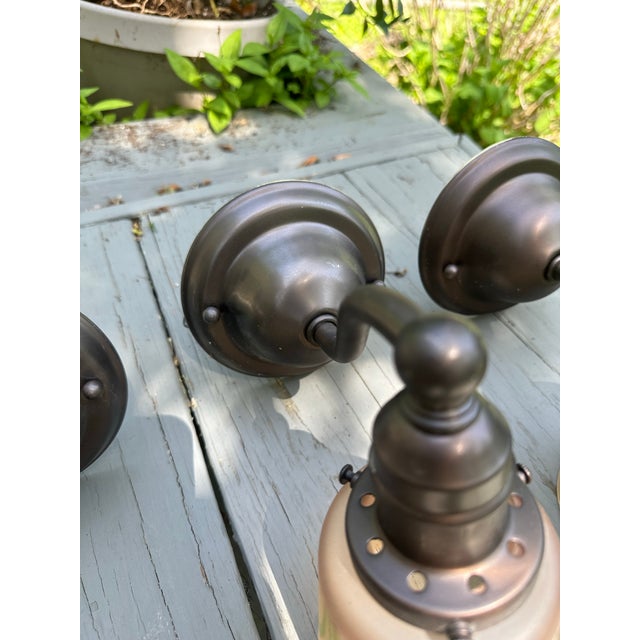 Old Lights On is pleased to offer this set of three antique brass wall sconces with vintage glass globes. They are wired...